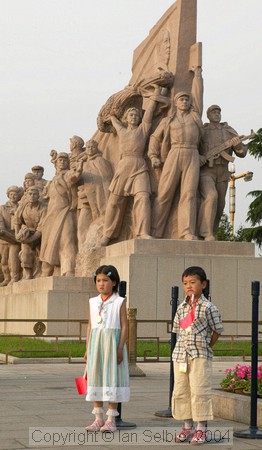 Two children posing uncomfortably in front of the heroes of the revolution, Tiannanmen Square, Beijing