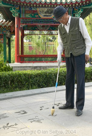 Non-permanent art - calligraphy using water on the paving stones, Gardens of the Forbidden City, Beijing