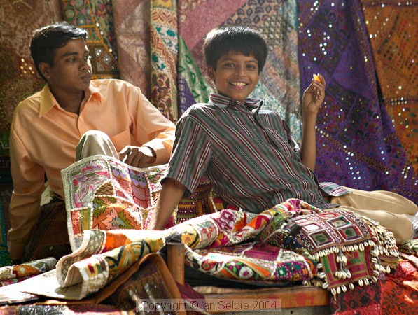Two boys playing among the wares at the Janpath Lane textiles market, Delhi