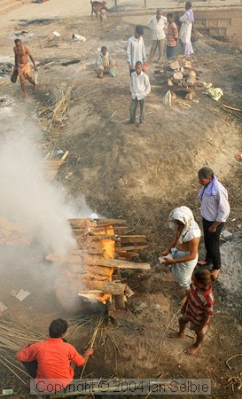 The body is placed on layers of wood, then further layers are piled on top.   Ghee and sandalwood oils are poured to speed the flames,  then the sacred flame is applied