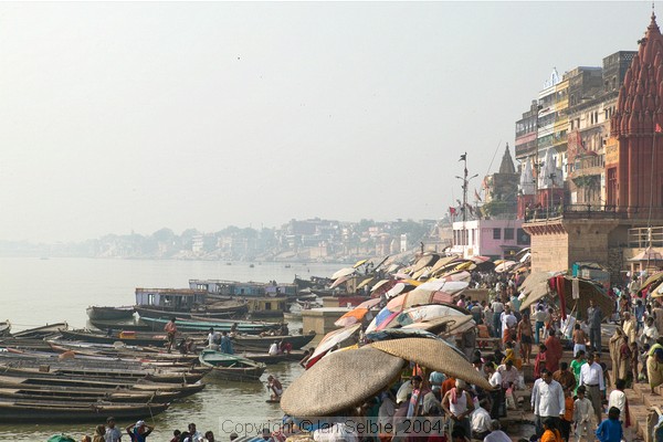 Boats and teeming humanity on the ghats at Varanasi, in the hazy early morning sun