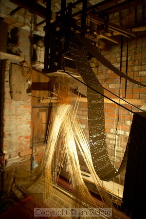 Silk weaver works in a room just big enough to hold the loom, Varanasi