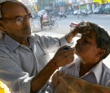 Roadside barber lathers up his customer, Jaipur