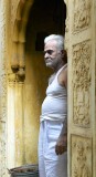 Man looking out  of carved sandstone doorway, Old Delhi