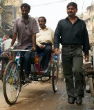 Trishaw driver with passenger, and pedestrian in the street, Old Delhi