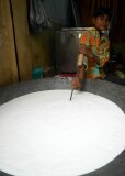 Boy stirring huge wok full of milk at the street market near the Tomb of Nizammudin, Delhi