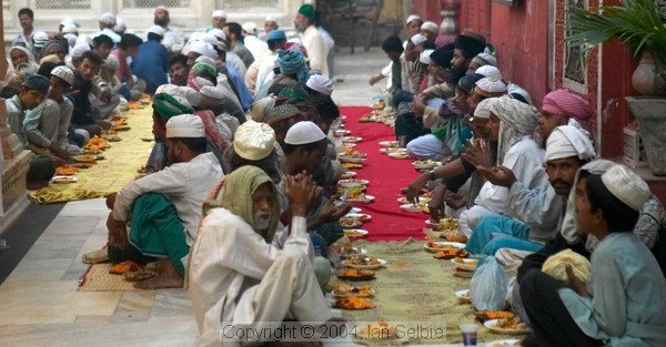 Men lined up with their food waiting for the break-fast at the Tomb of Nizammudin, Delhi