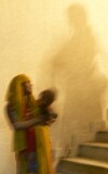Behind the scenes at the Delhi arts and crafts exhibition, workers are carrying building materials up the shadowy stairway.  The baby came along for the ride.