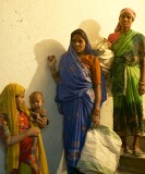 Behind the scenes at the Delhi arts and crafts exhibition, workers are carrying building materials up the shadowy stairway.  The baby came along for the ride.