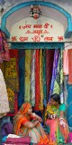 Two sales ladies chatting among their wares at the Janpath Lane textiles market, Delhi