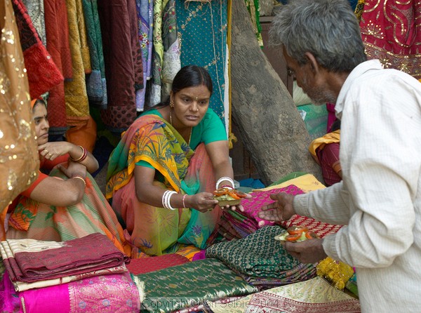 Two sales ladies buying lunch at the Janpath Lane textiles market, Delhi