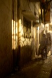 Nizammudin district, Delhi.  A side alley poorly lit, but with constant human traffic in the rather mysterious light cast by the windows of the adjacent house.