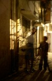 Nizammudin district, Delhi.  A side alley poorly lit, but with constant human traffic in the rather mysterious light cast by the windows of the adjacent house.