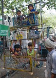 Children having a ride on a hand operated ferris wheel, Chandni Chowk, Old Delhi