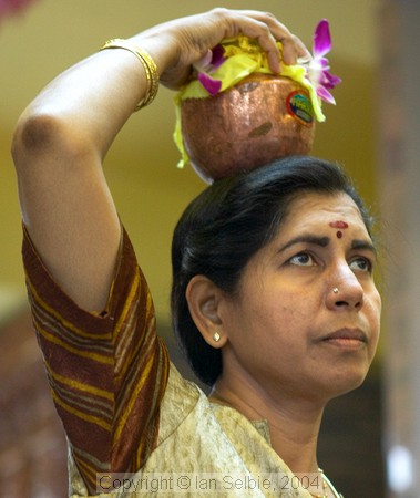 Woman carrying pot of milk on her head at celebration of the birthday of Lord Ganesha at Sri Senpaga Vinayagar Temple, Ceylon Road, Singapore