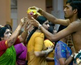 Priest handing ouit milk at celebration of the birthday of Lord Ganesha at Sri Senpaga Vinayagar Temple, Ceylon Road, Singapore