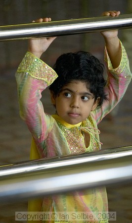 Child watching celebration of the Depavali Festival at Sri Senpaga Vinayagar Temple, Ceylon Road, Singapore
