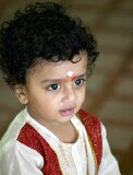 Child watching celebration of the Depavali Festival at Sri Senpaga Vinayagar Temple, Ceylon Road, Singapore
