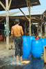 Fisherman takes his bath on the deck with water from barrels