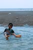 Playing in the black sand and sea at Mersing beach