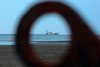 View of a ship at sea through the eyelet of a raft