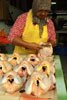 The chicken lady cleans a chicken at her stall