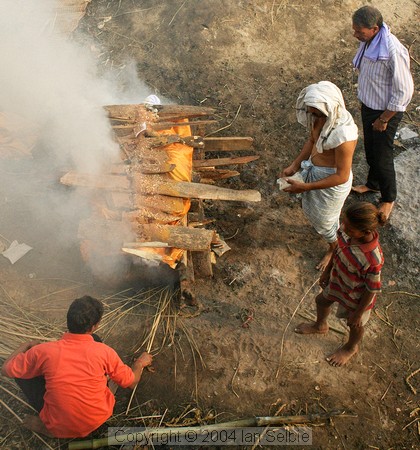 The body is placed on layers of wood, then further layers are piled on top.   Ghee and sandalwood oils are poured to speed the flames,  then the sacred flame is applied