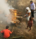 The body is placed on layers of wood, then further layers are piled on top.   Ghee and sandalwood oils are poured to speed the flames,  then the sacred flame is applied