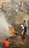 The body is placed on layers of wood, then further layers are piled on top.   Ghee and sandalwood oils are poured to speed the flames,  then the sacred flame is applied