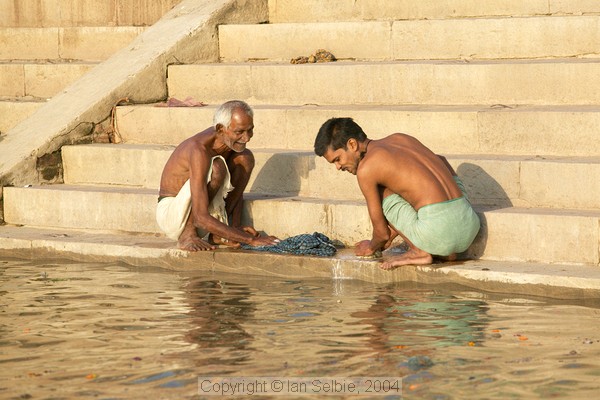 Men share a joke while washing clothes