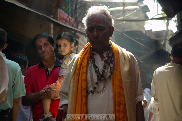 Crowds press by in the narrow and sometimes dark lanes, with the occasional sunbeam