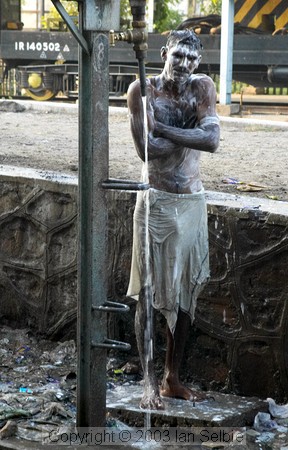 Man having a cold shower on the railway tracks, Jaipur
