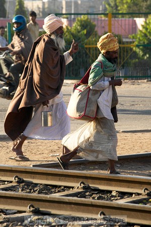 Two holy men walking along the railway tracks, Jaipur